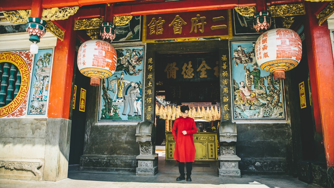 Person in red standing in ornate temple entrance